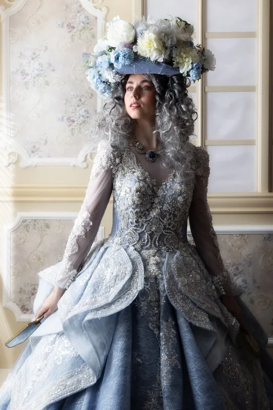 Vicky im silbern bestickten Märchenkleid mit Blumenkrone vor einem hellen Fenster